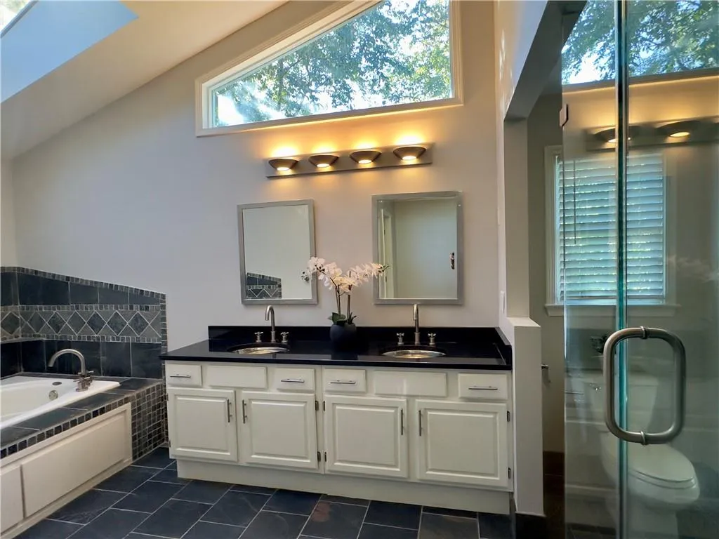 Primary bathroom with glass shower, jacuzzi tub