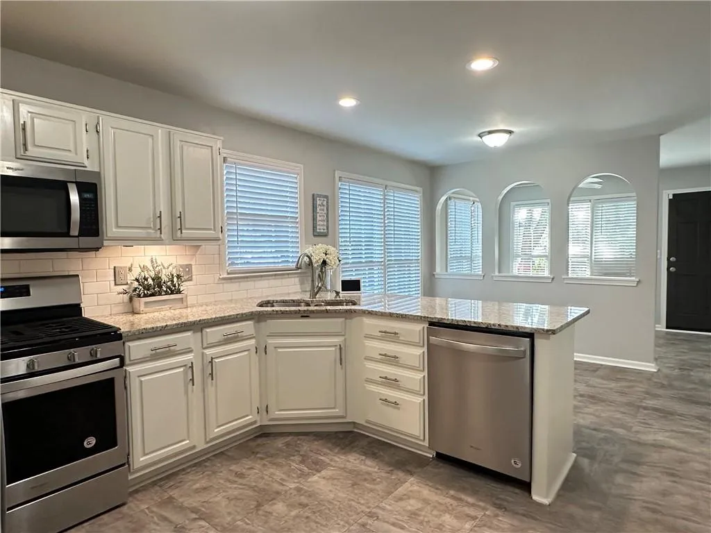 Spacious open kitchen with breakfast bar, eat in area & sunroom