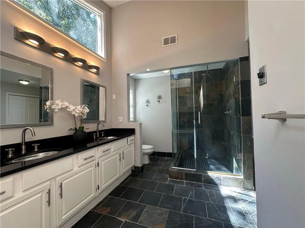 Primary bathroom with glass shower, double sinks