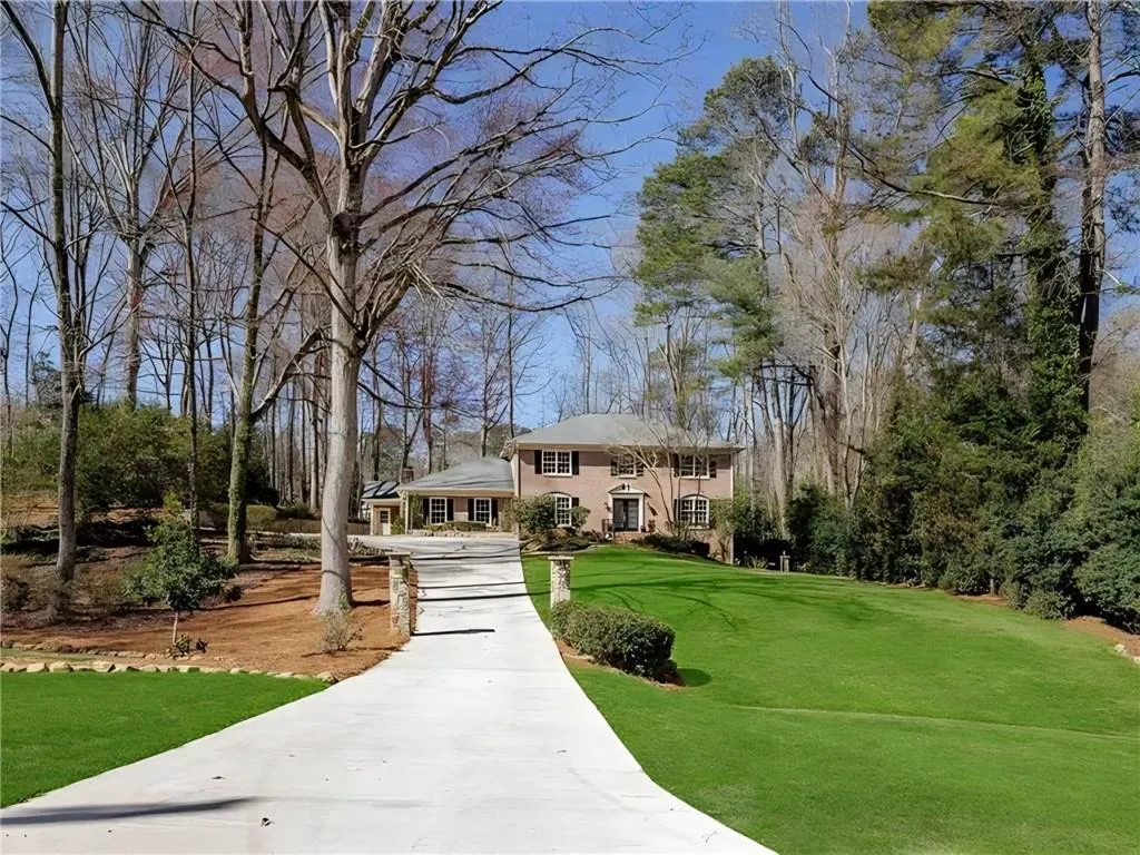 Full view of long driveway and front lawn