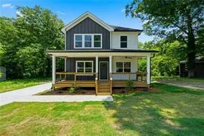 Two-story residence featuring a covered front porch, composite siding, and a concrete driveway