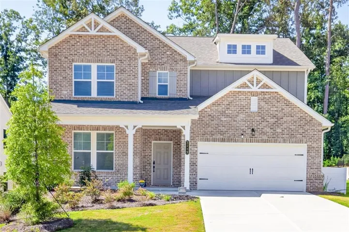 Brick and siding exterior featuring a two-car garage with a concrete driveway