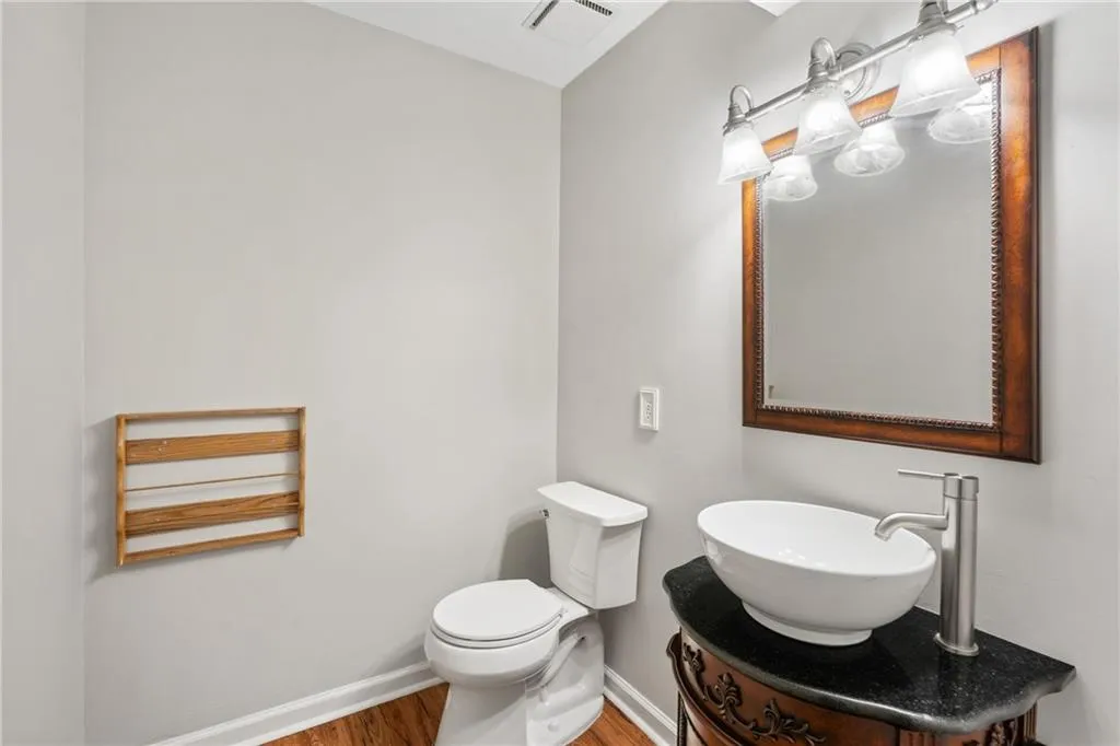 Bathroom featuring vanity, wood-type flooring, and toilet