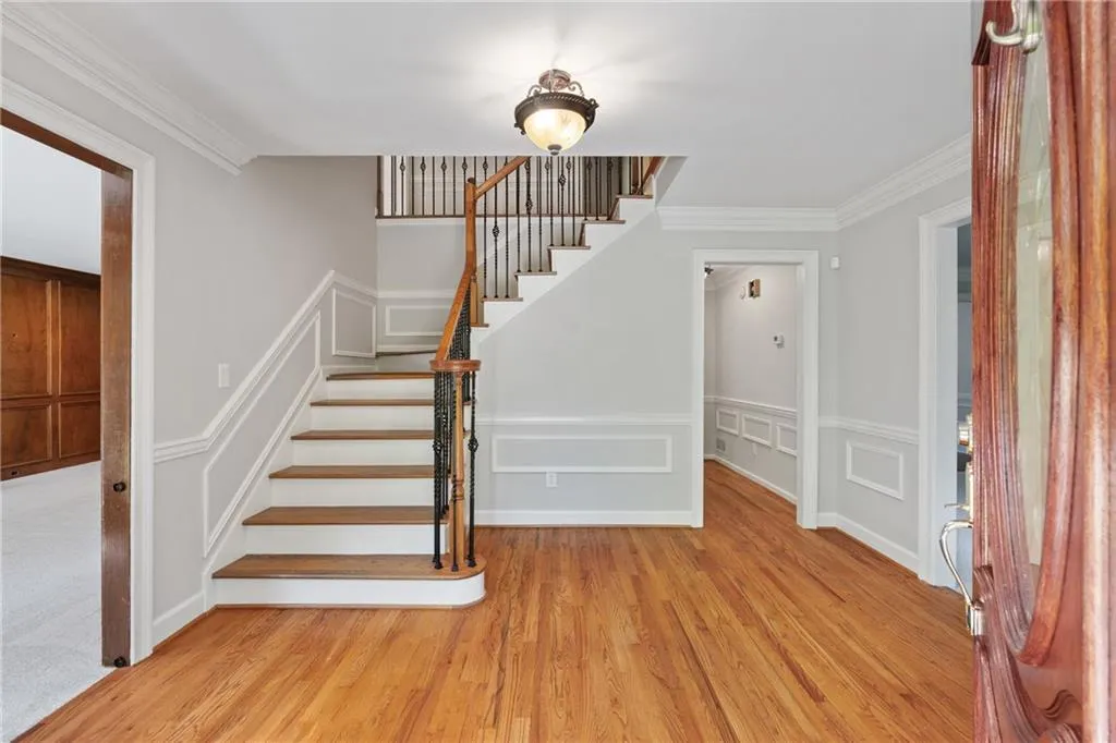 Stairs featuring crown molding and light hardwood / wood-style flooring