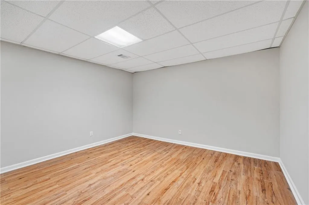 Spare room with light hardwood / wood-style flooring and a drop ceiling