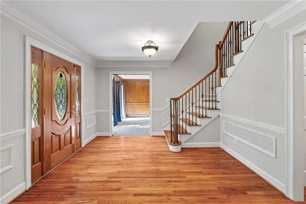 Foyer entrance with crown molding and light hardwood / wood-style flooring