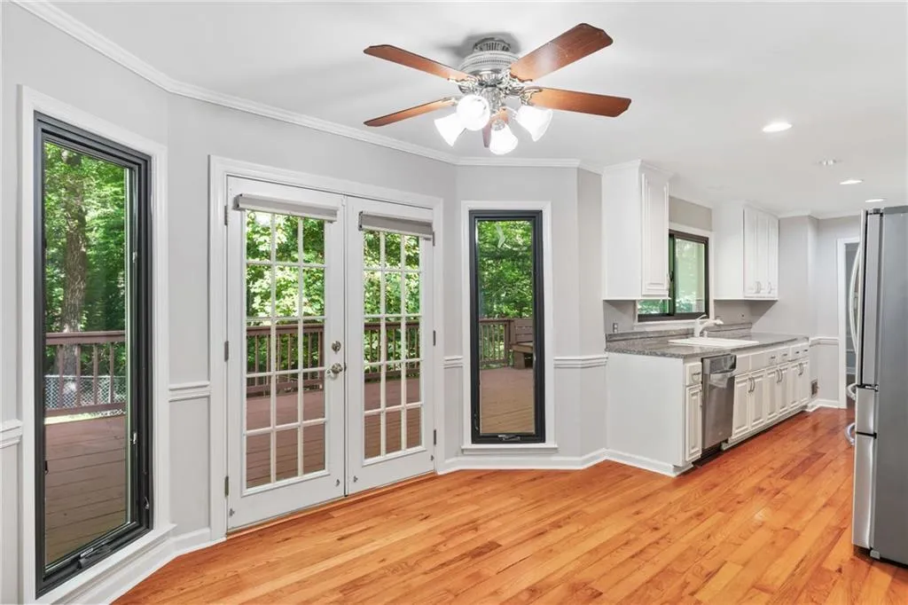 Kitchen with white cabinetry, ceiling fan, light hardwood / wood-style floors, appliances with stainless steel finishes, and a wealth of natural light