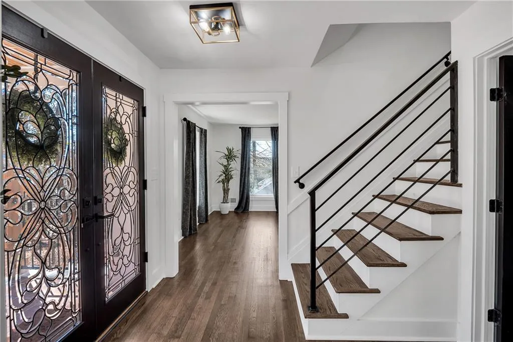 Entryway with french doors, stairs, baseboards, and dark wood-style flooring