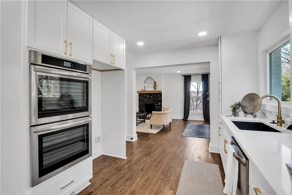 Kitchen featuring a sink, a wealth of natural light, a high end fireplace, and stainless steel appliances