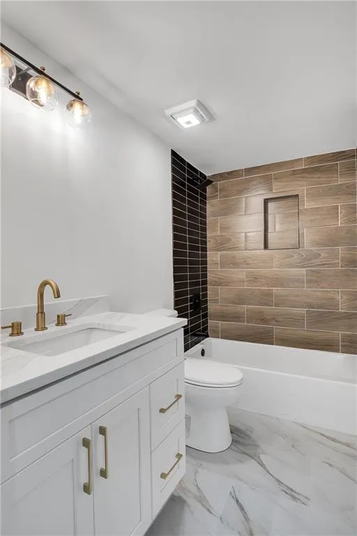 Bathroom featuring vanity, toilet, bathtub / shower combination, and marble finish floor