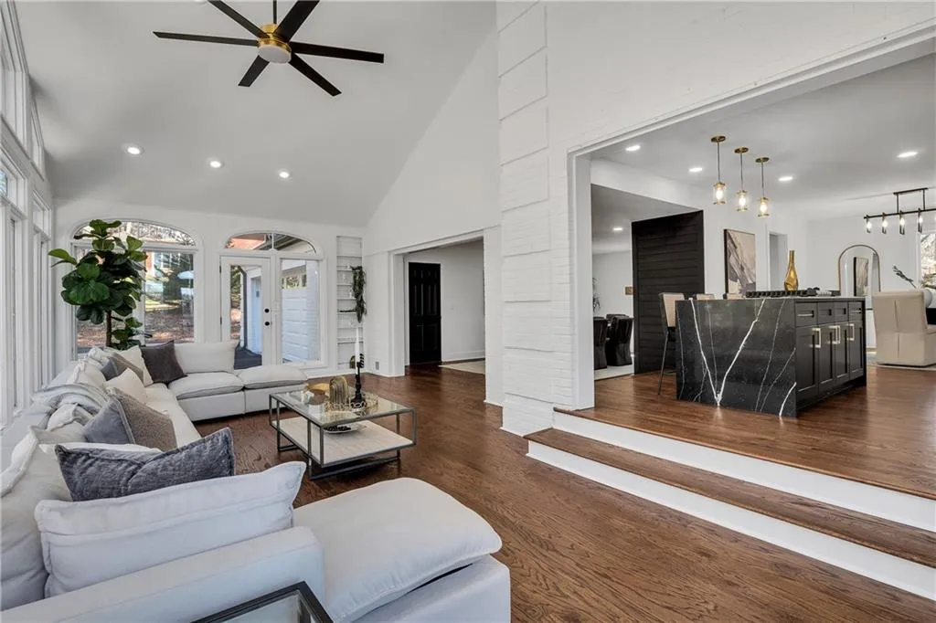 Living room featuring recessed lighting, high vaulted ceiling, dark wood-type flooring, and ceiling fan
