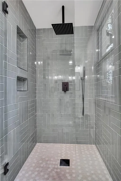 Full bath featuring tiled shower