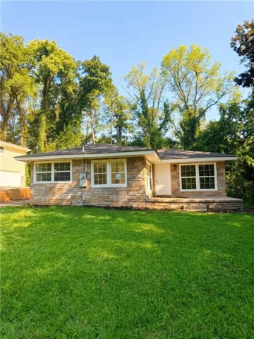 Stone veneer exterior, white door, and multiple windows