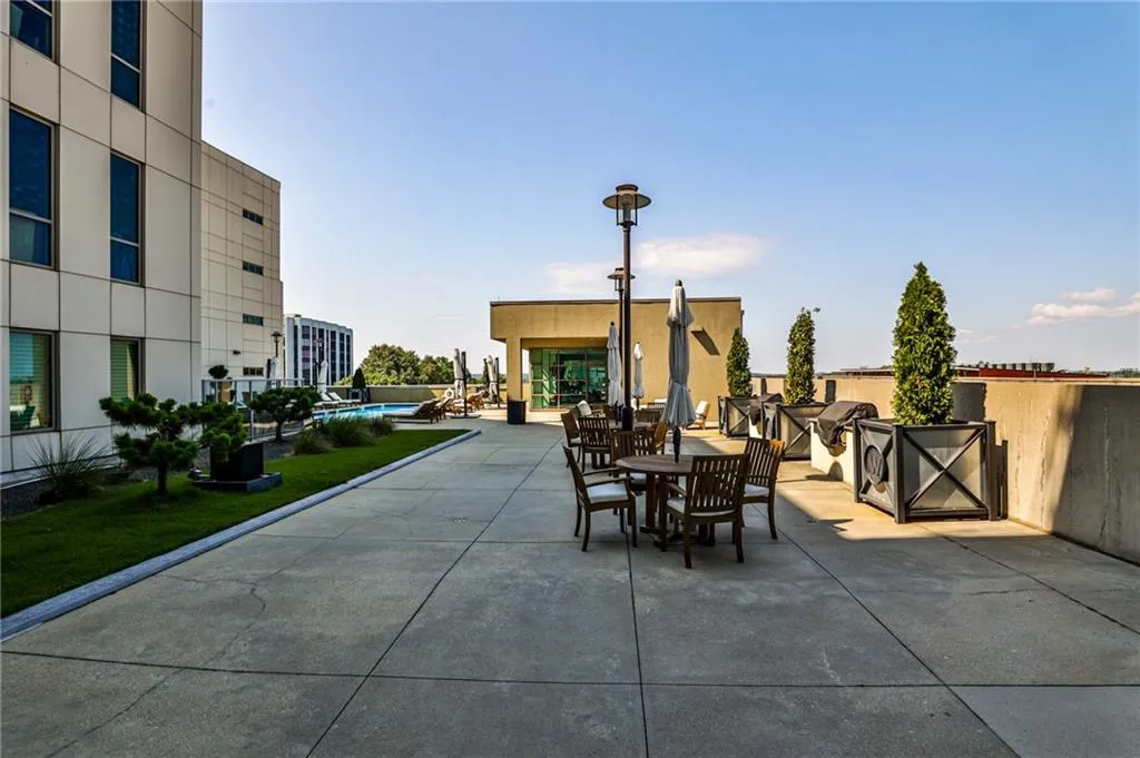 Spacious rooftop community area featuring grilling stations, dining space, and lush landscaping—perfect for entertaining or relaxing outdoors