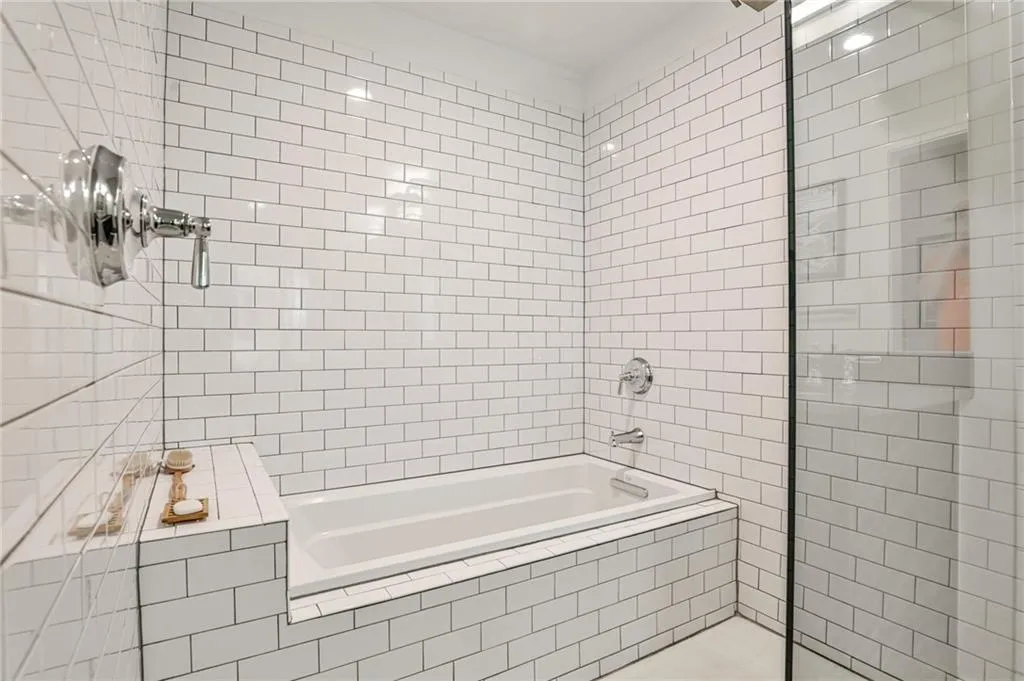 Separate soaking tub and shower with full-height subway tile