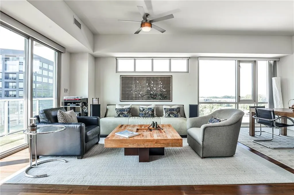 Bright and inviting living space with hardwood floors, modern finishes, and treetop views