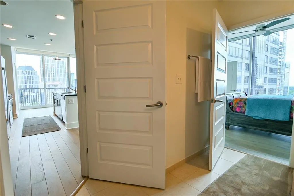 Hallway with healthy amount of natural light, light wood-style floors, recessed lighting, and expansive windows