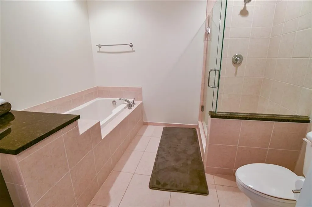 Bathroom with a shower stall, tile patterned floors, and a garden tub