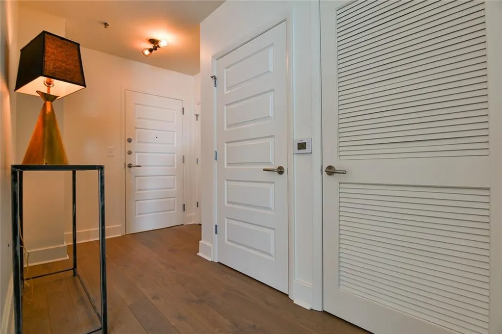 Hallway with dark wood-type flooring and baseboards