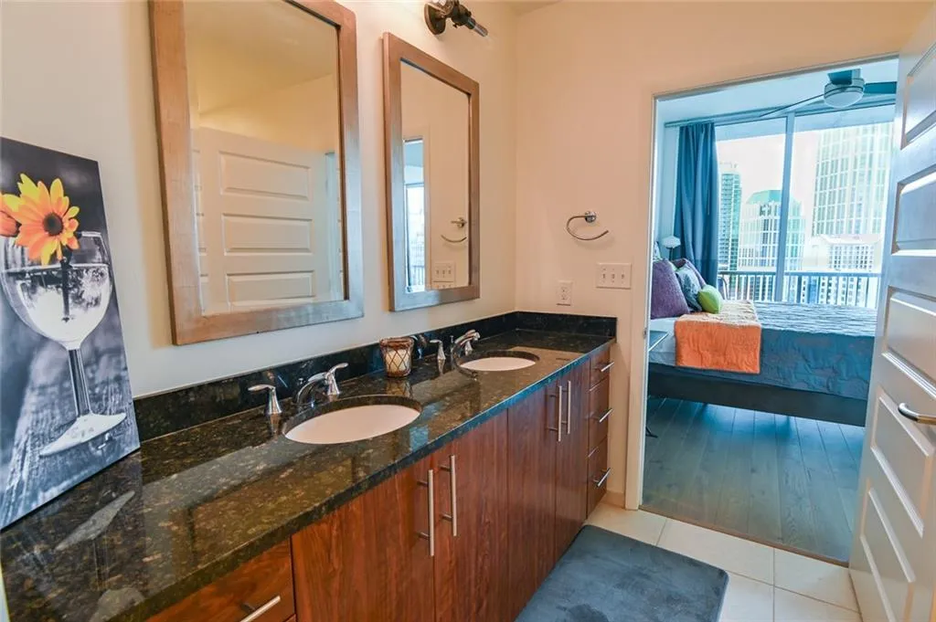 Bathroom with ensuite bath, double vanity, and tile patterned floors