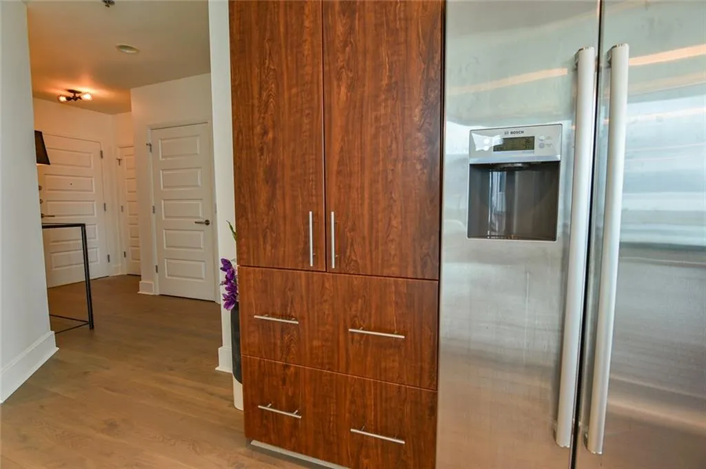 Kitchen featuring stainless steel fridge with ice dispenser and wood finished floors