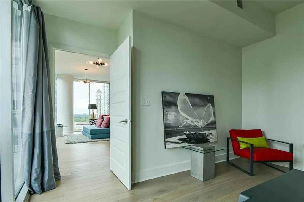 Sitting room featuring wood finished floors, a baseboard heating unit, and a chandelier