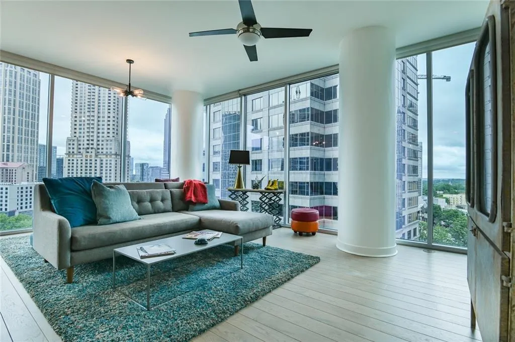 Living room featuring floor to ceiling windows, plenty of natural light, wood-type flooring, and a view of city