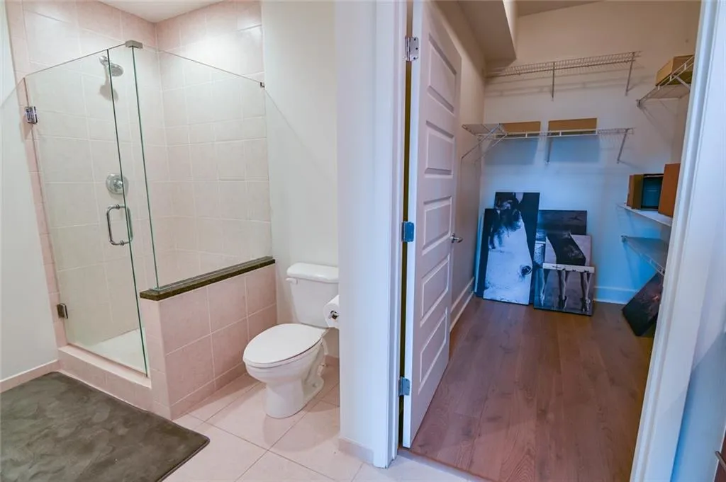 Full bath with a shower stall, a walk in closet, and tile patterned flooring