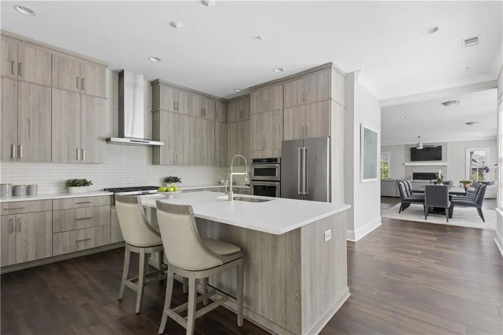 Chic kitchen with custom cabinets to the ceiling, under cabinet lighting, 6 burner gas range, stainless appliances and beautiful quartz countertops.