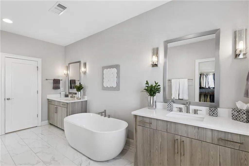 Primary bath suite with dual vanities, custom cabinetry, soaking tub and oversized shower.