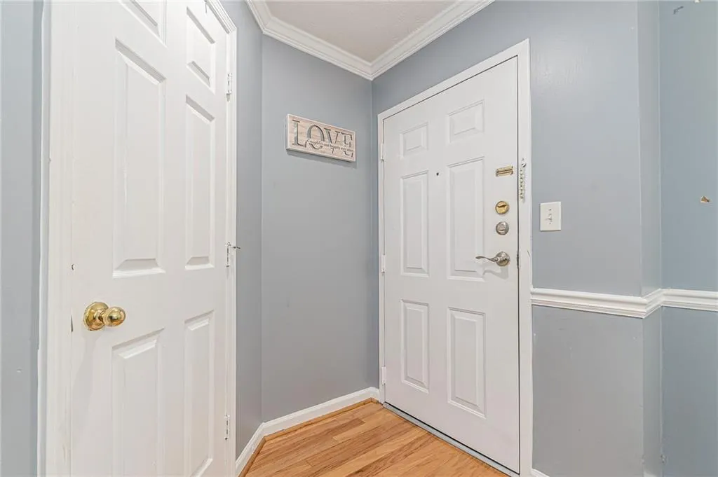 Doorway featuring ornamental molding and wood finished floors