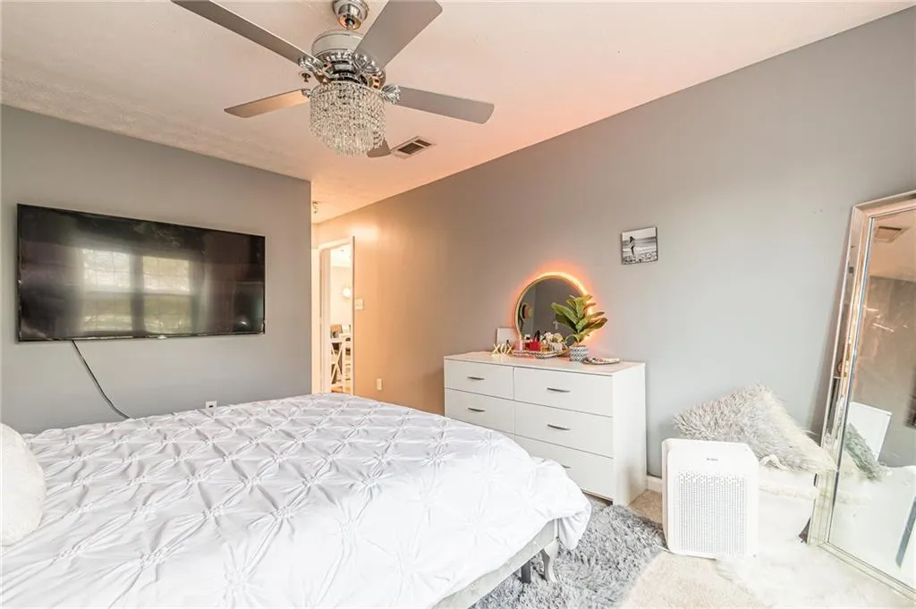 Bedroom with ceiling fan and light colored carpet