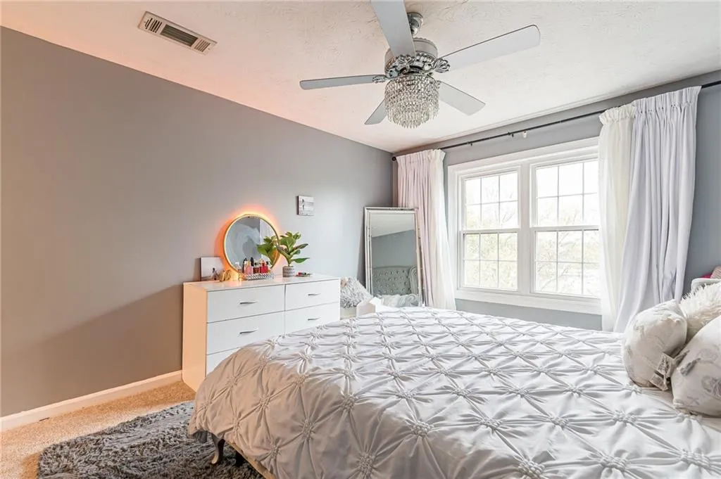 Bedroom featuring light colored carpet, a textured ceiling, and ceiling fan
