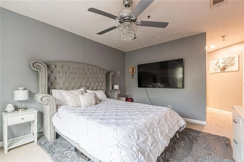 Bedroom with light colored carpet and ceiling fan