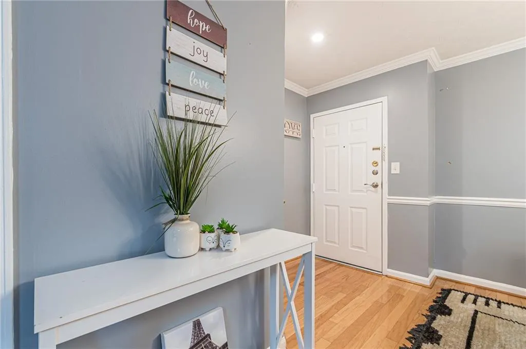 Entryway with light wood-style flooring, crown molding, and recessed lighting
