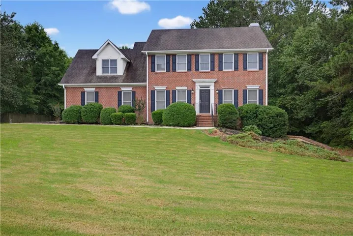 Traditional brick exterior featuring a prominent gabled dormer and dark shutters