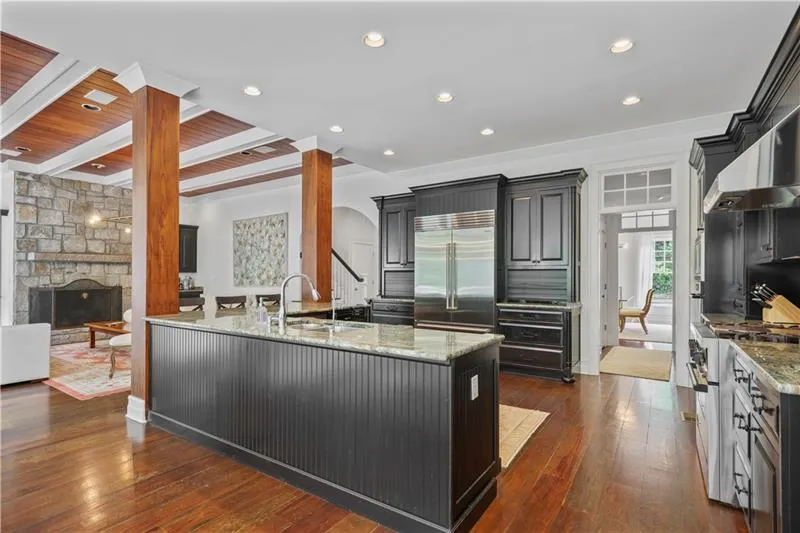 Kitchen open to family room with large stone fireplace