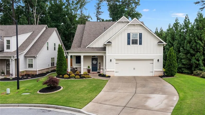 White vertical siding residence with a covered front porch and a two-car garage