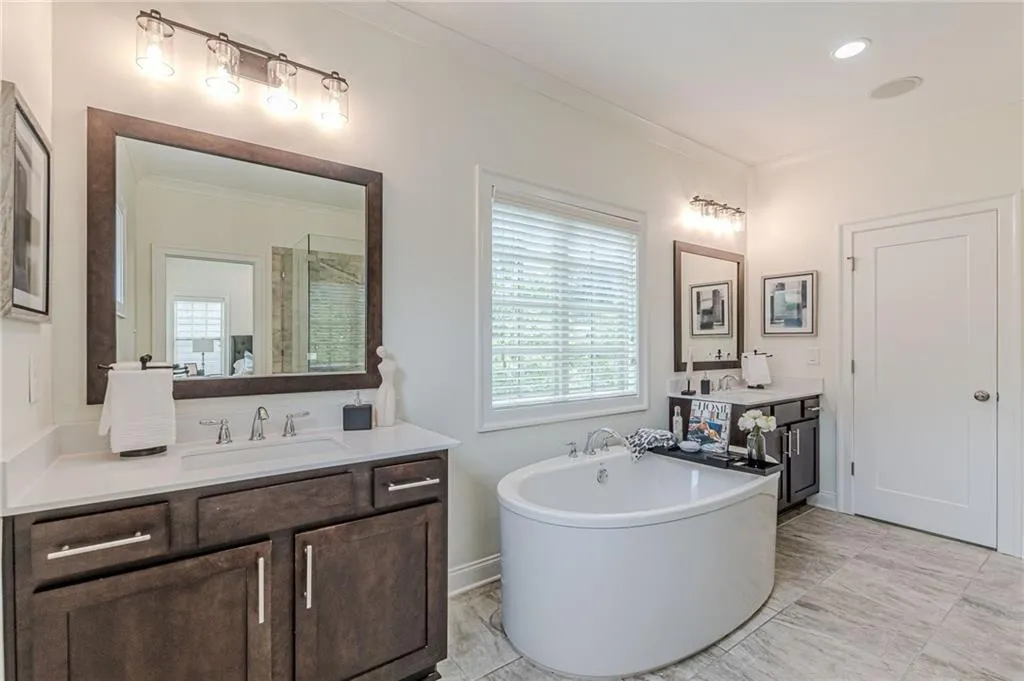 Bathroom featuring tile patterned floors, a bath, and double vanity