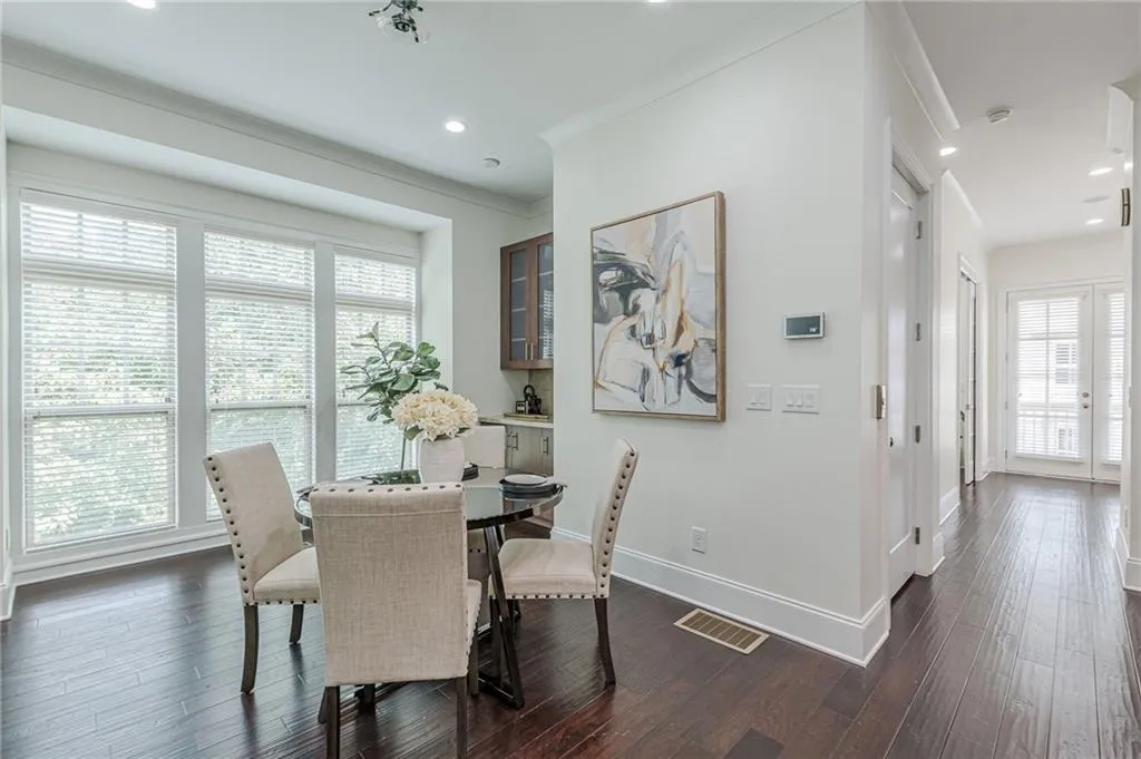 Dining room featuring a healthy amount of sunlight, dark hardwood / wood-style flooring, and ornamental molding