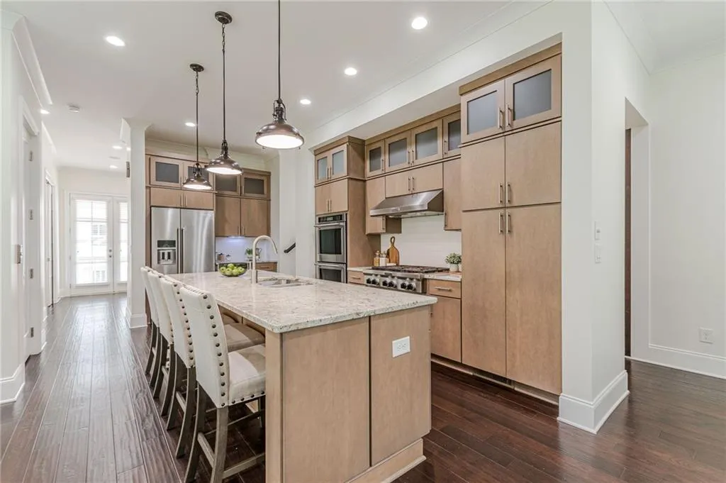 Kitchen featuring tasteful backsplash, dark hardwood / wood-style flooring, an island with sink, stainless steel appliances, and sink