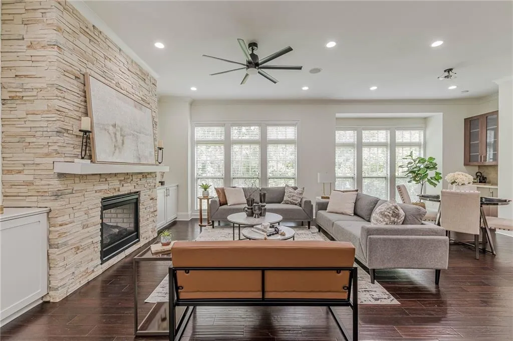 Living room featuring ornamental molding, dark hardwood / wood-style flooring, a fireplace, and ceiling fan