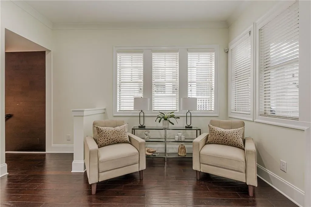 Sitting room with hardwood / wood-style flooring and crown molding