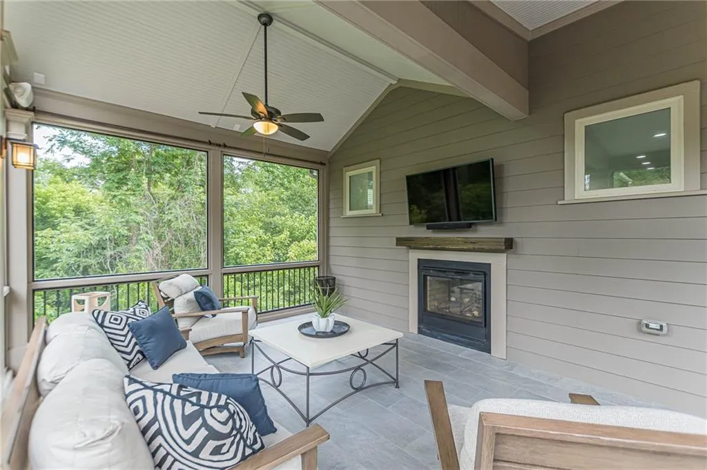 Sunroom / solarium with lofted ceiling, ceiling fan, and plenty of natural light
