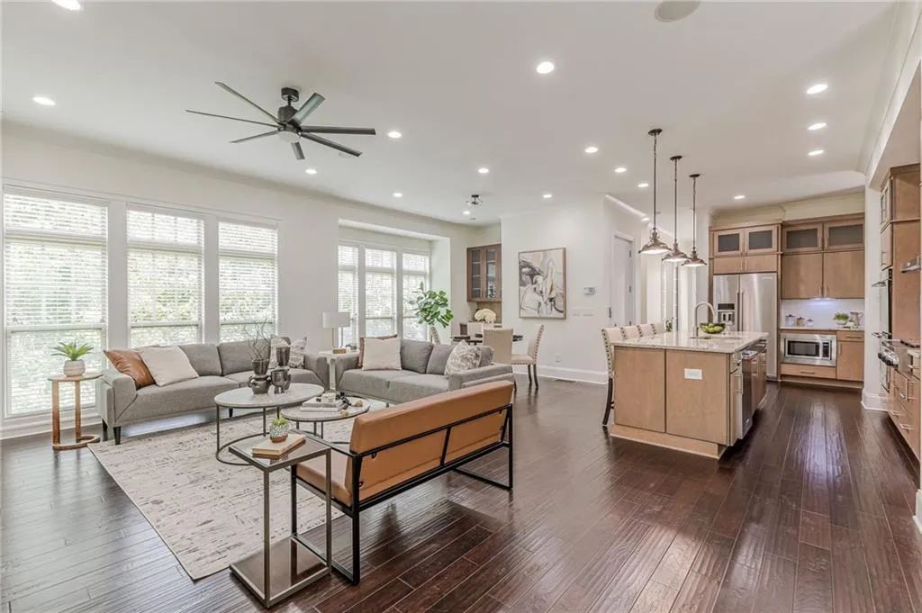 Living room featuring ornamental molding, sink, ceiling fan, and dark wood-type flooring