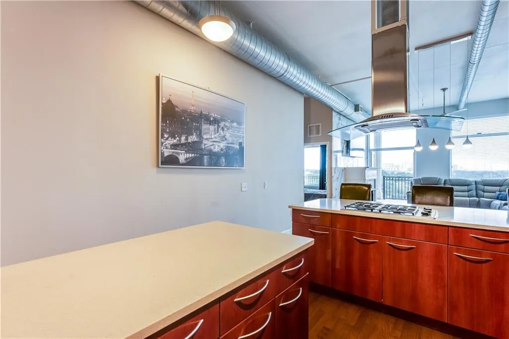 Kitchen with visible vents, island exhaust hood, open floor plan, light countertops, and stainless steel gas cooktop