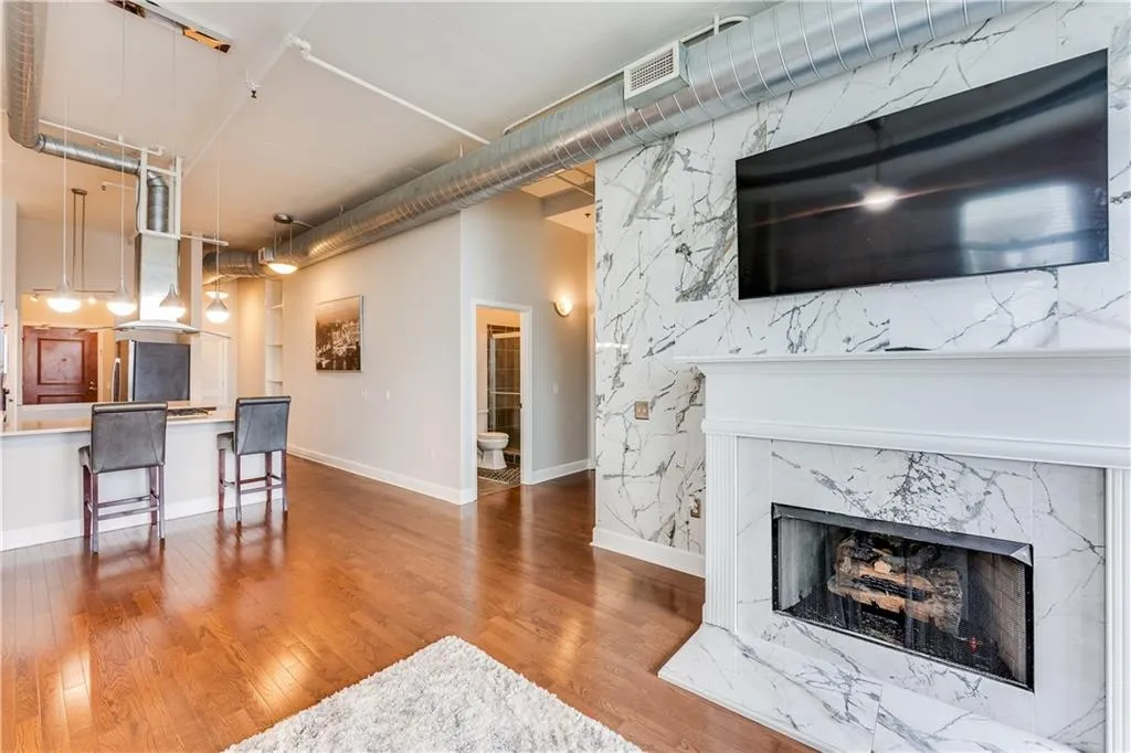 Living area with wood finished floors, baseboards, and a premium fireplace