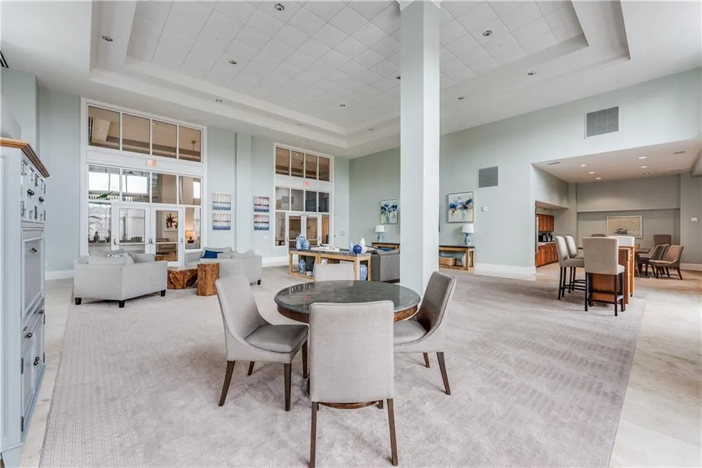 Dining room featuring ornate columns, a raised ceiling, visible vents, and a towering ceiling