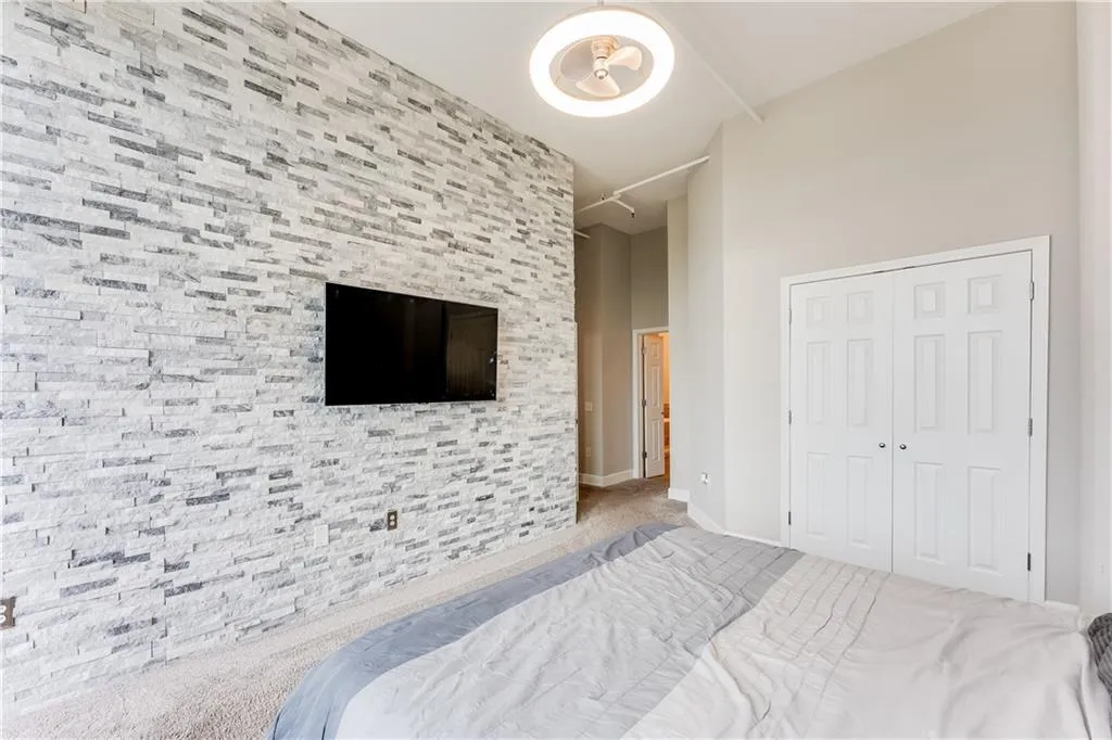 Carpeted bedroom featuring baseboards, a closet, and a towering ceiling