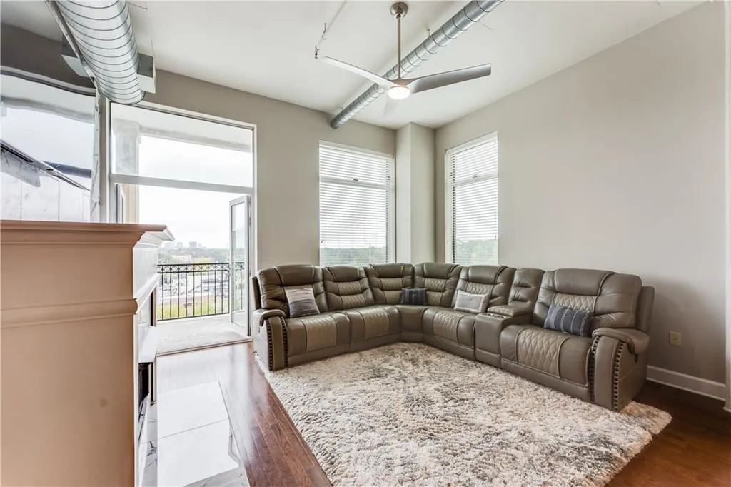Living area with baseboards, a ceiling fan, and dark wood-style flooring